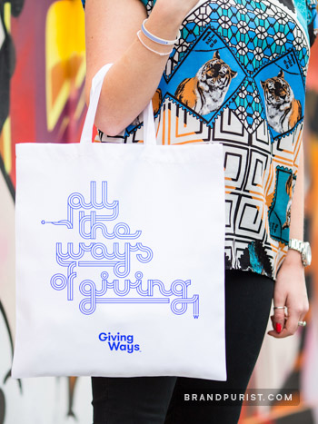 White tote bag with a type design 'All the ways of Giving' derived from the GivingWays logo mark.