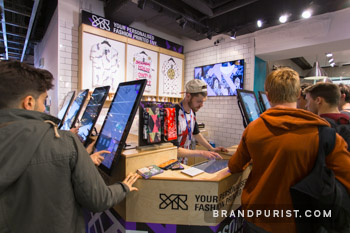 Close-up of customers engaging with YR Store’s interactive touchscreens at Topman’s Oxford Circus location.