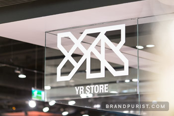 YR Store logo showcased on glass signage at Topshop for brand recognition.