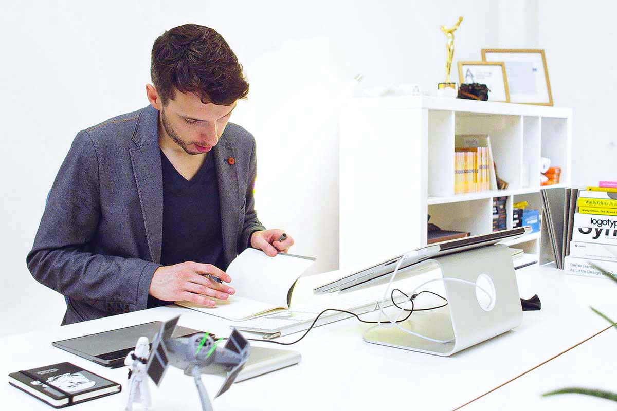 Designer making research notes at his desk.