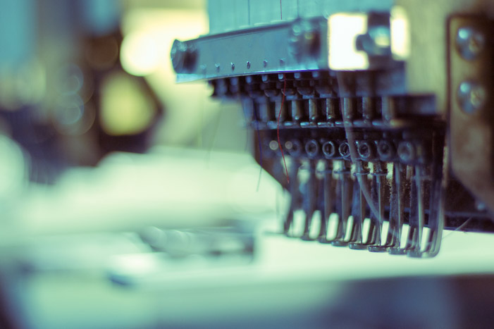 Close-up photography of embroidery machine heads at the ICON Printing studio.