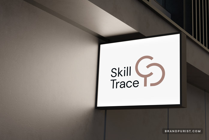 Small lightbox signage on a building’s facade at night, featuring the Skill Trace logo.