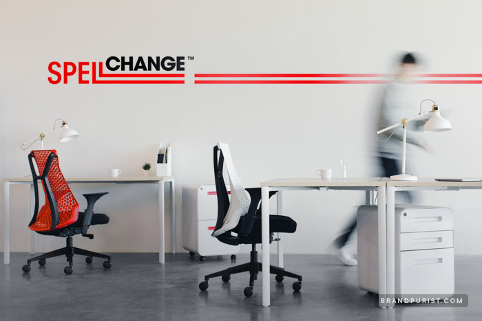 Modern office space with red and black Spell Change logo on a white wall.