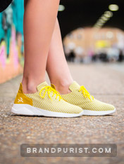 Close-up photo of women’s trainer in yellow shot for the URTA lookbook in Shoreditch, London.