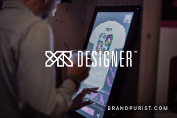 YR Designer logo overlaid on a photo of an interactive touchscreen. 